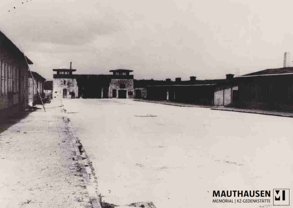 4.1.0044.jpg; 4.1.0044; KZ-Gedenkstätte Mauthausen: Ehemaliger Appellplatz, Blickrichtung Jourhaus (Lagertor) und Baracke 1, Küchenbaracke mit angelehnter Leiter, vermutlich für Dacharbeiten, Aufnahme unterbelichtet;
