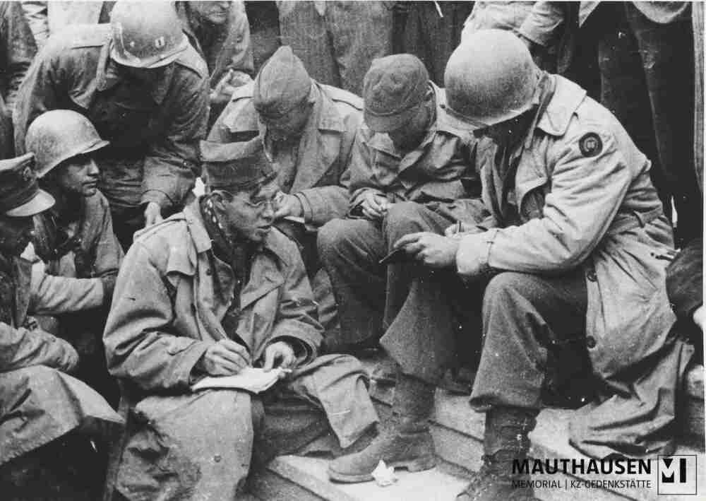 4.1.0925.jpg; 4.1.0925; Befreites KZ Mauthausen: Der ehemalige US-amerikanische Häftling Jack Taylor informiert auf den Stufen zum Kommandanturgebäude eine Gruppe von Reportern und Soldaten der US Army über das KZ Mauthausen, 5. oder 6. Mai 1945;