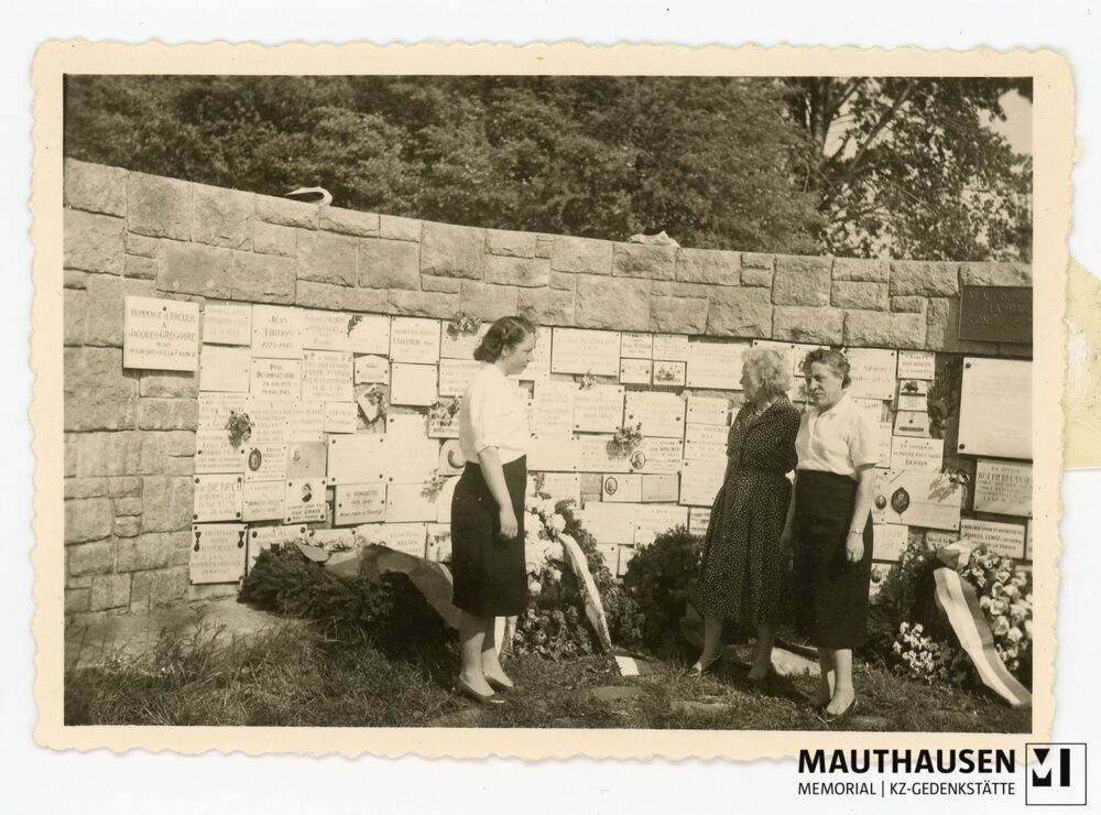 4.16.0037.jpg; 4.16.0037; KZ Gedenkstätte Mauthausen: Simone Bonnet, ihre Mutter Marcelle Bonnet und Suzanne Felix stehen vor der mit Gedenktafeln und Kränzen versehenen Gedenkwand beim französischen Denkmal. ;