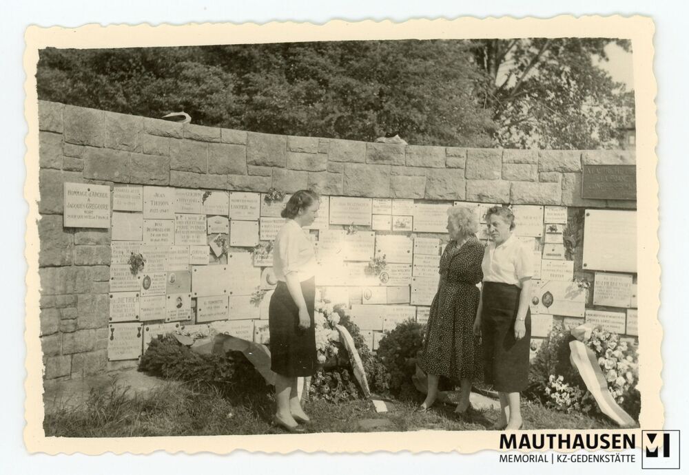 4.16.0049.jpg; 4.16.0049; KZ Gedenkstätte Mauthausen: Simone (links außen) und Marcelle (rechts außen) Bonnet stehen gemeinsam mit einer weiteren Frau vor der Gedenkwand beim Französischen Denkmal;