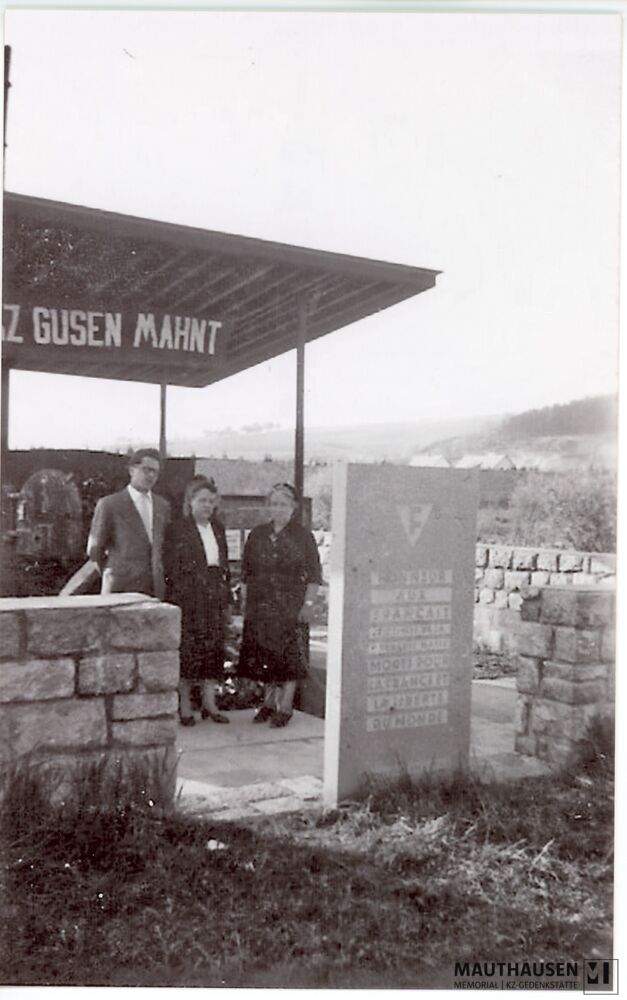 4.16.0071.jpg; 4.16.0071; Areal des ehemaligen KZ Gusen: Marcelle Bonnet (Mitte) steht mit zwei weiteren Personen beim ehemaligen Krematorium;