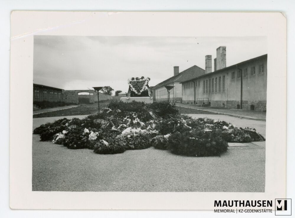 4.16.0090.jpg; 4.16.0090; KZ Gedenkstätte Mauthausen: Blick auf den mit Blumenkränzen umgebenen Sarkophag am ehemaligen Appellplatz;