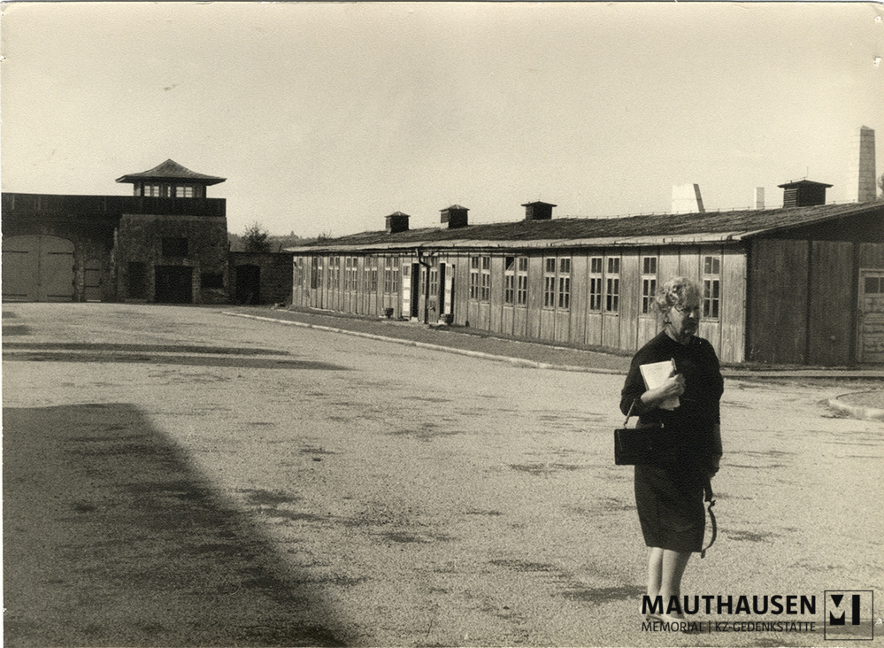 MM_4_15_003.jpg; 4.15.003; KZ Gedenkstätte Mauthausen: Miriam Novitch spaziert, mit einem Notizbuch in der Hand, über den ehemaligen Appellplatz.; Fotografie
