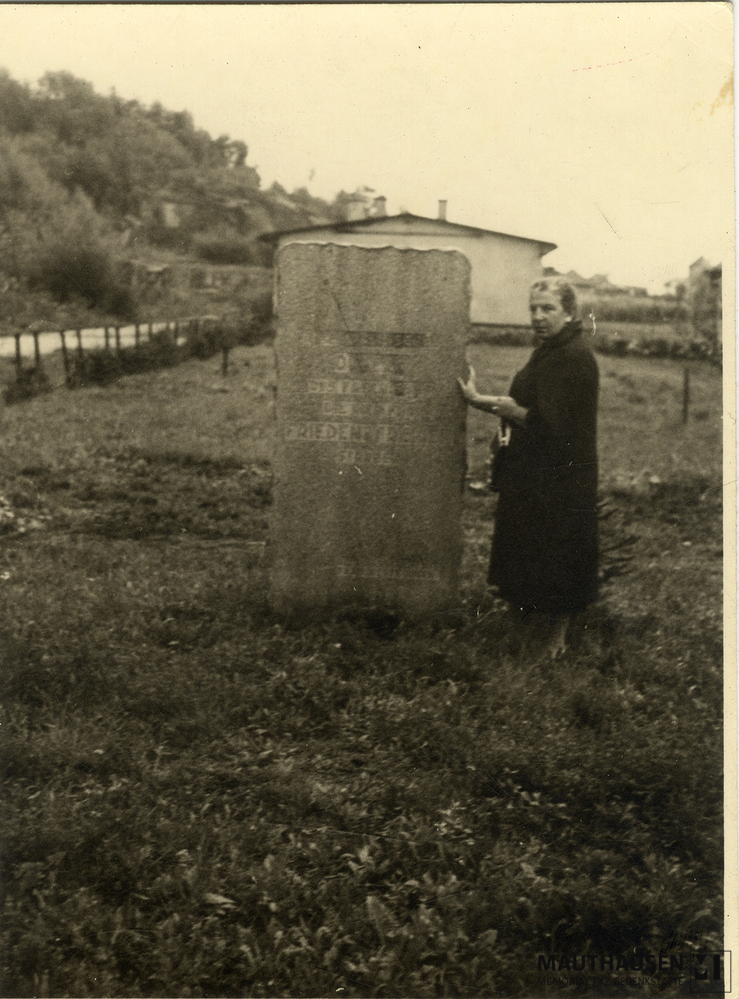 MM_4_15_007.jpg; 4.15.007; Areal des ehemaligen Konzentrationslagers Gusen: Miriam Novitch steht seitlich neben einem Gedenkstein.; Fotografie