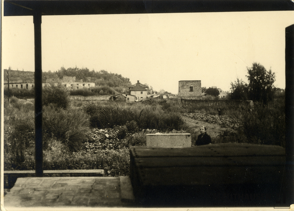 MM_4_15_009.jpg; 4.15.009; Areal des ehemaligen Konzentrationslagers Gusen: Miriam Novitch steht vor dem Krematorium, dessen Reste eine inoffizielle Gedenkstätte bilden.; Fotografie