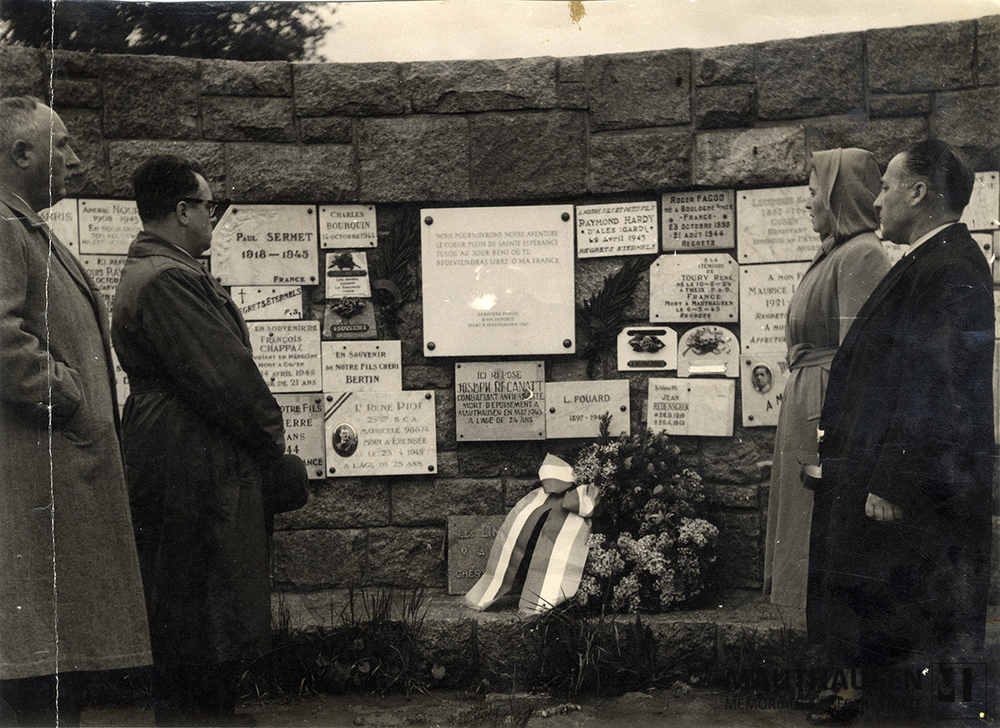 MM_4_15_024.jpg; 4.15.024; KZ Gedenkstätte Mauthausen: Besucher*innen stehen in der Innenseite des französischen Denkmals, vor einer Mauer mit Gedenktafeln, die an die französische KZ-Opfer erinnern. ; Fotografie