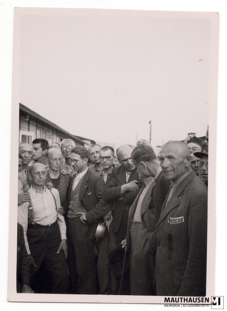 MM_4_7_4_0005.jpg; 4.7.4.0005; Befreites KZ Mauthausen: Louis Häfliger, Delegierter des Internationalen Komitees vom Roten Kreuz, umringt von einer Gruppe Überlebender im befreiten Lager ;