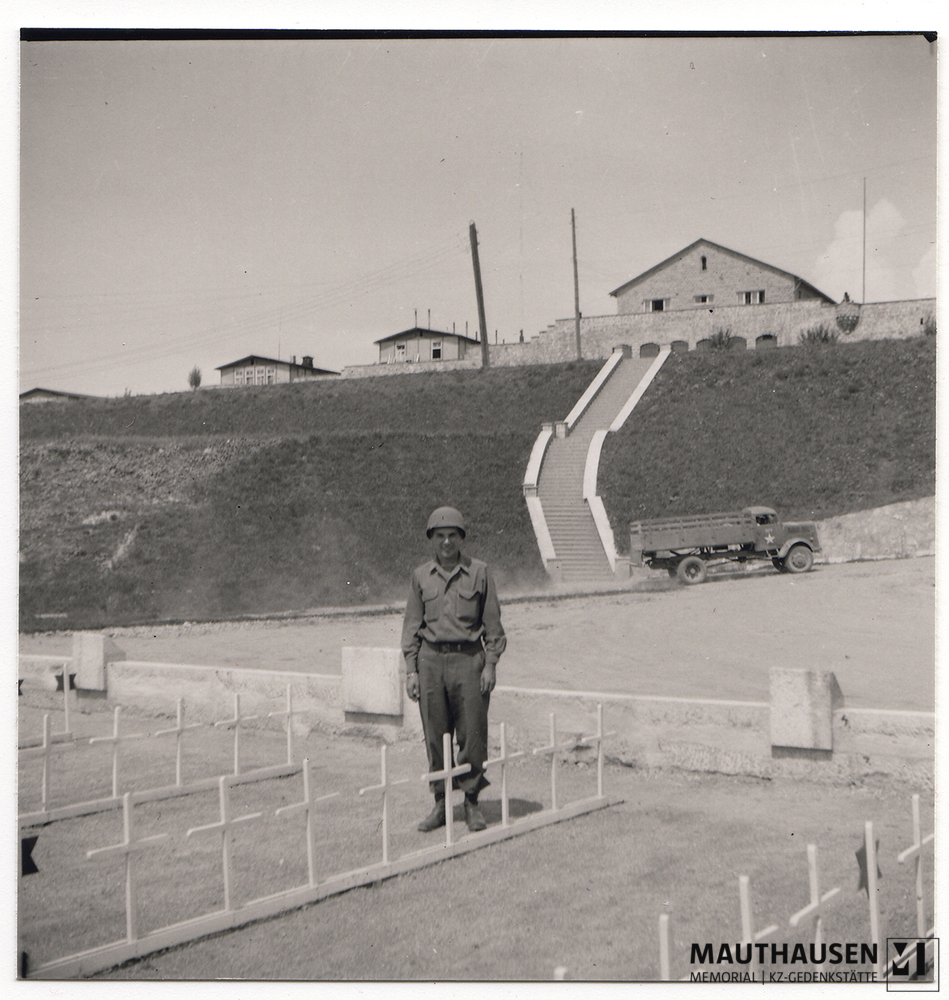 MM_4_7_5_0012.jpg; 4.7.5.0012; Befreites KZ Mauthausen: Ein amerikanischer Soldat posiert beim Massengrab auf dem ehemaligen Sportplatz der SS.;